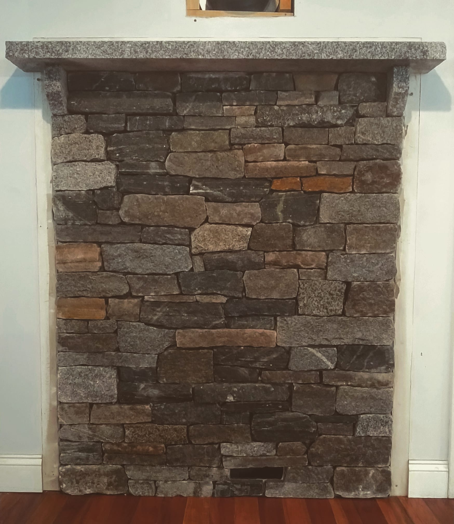 Warm and cozy is this New England style heat shield for small wood stove. The mantle was hand-split and notched from a Woodbury granite tread.