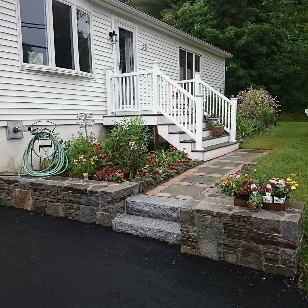 A mixture of fieldstone and quarry stone went into these retaining walls, flanking a reclaimed paver walkway. Gorham, Maine